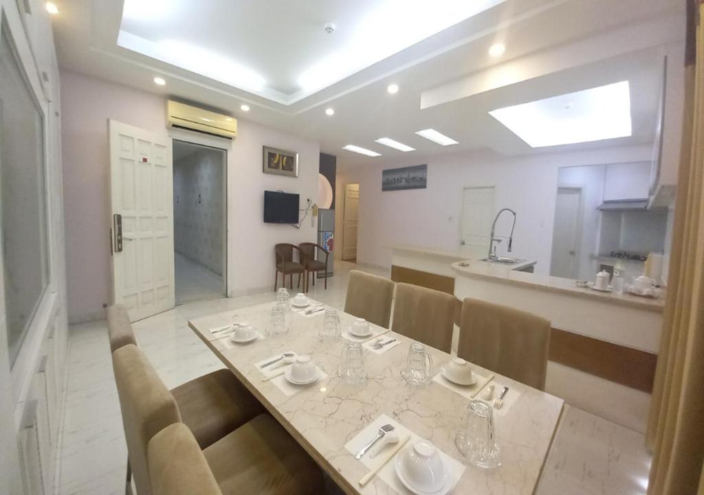 胡志明市凯欢公寓式酒店的一间带桌椅的用餐室和一间厨房