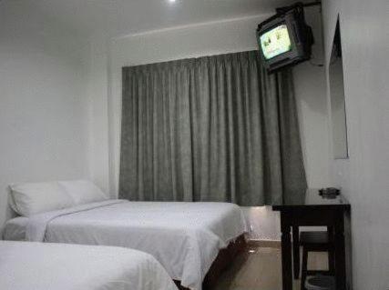 瓦卡夫车叶王朝酒店 - 瓦卡车叶的酒店客房设有两张床和电视。