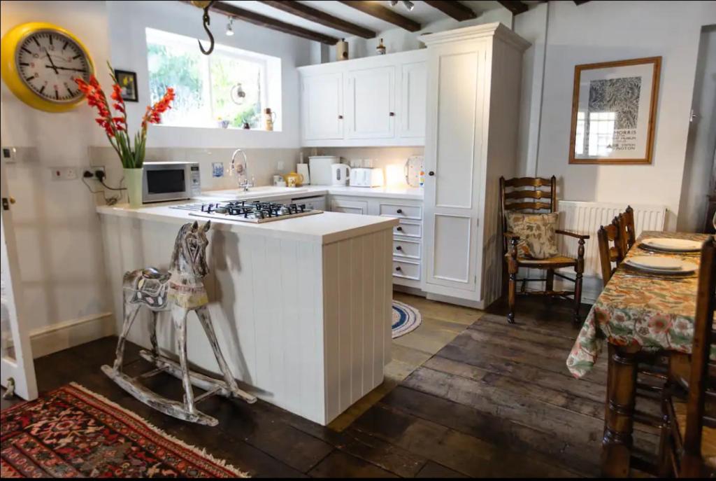 勒德洛Pass the Keys Magical period house in the heart of Ludlow的厨房配有白色橱柜和炉灶烤箱。