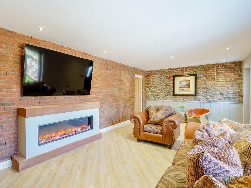 Bowness-on-SolwayThe Barnacle Goose - Uk35261的客厅设有壁炉和砖墙上的电视