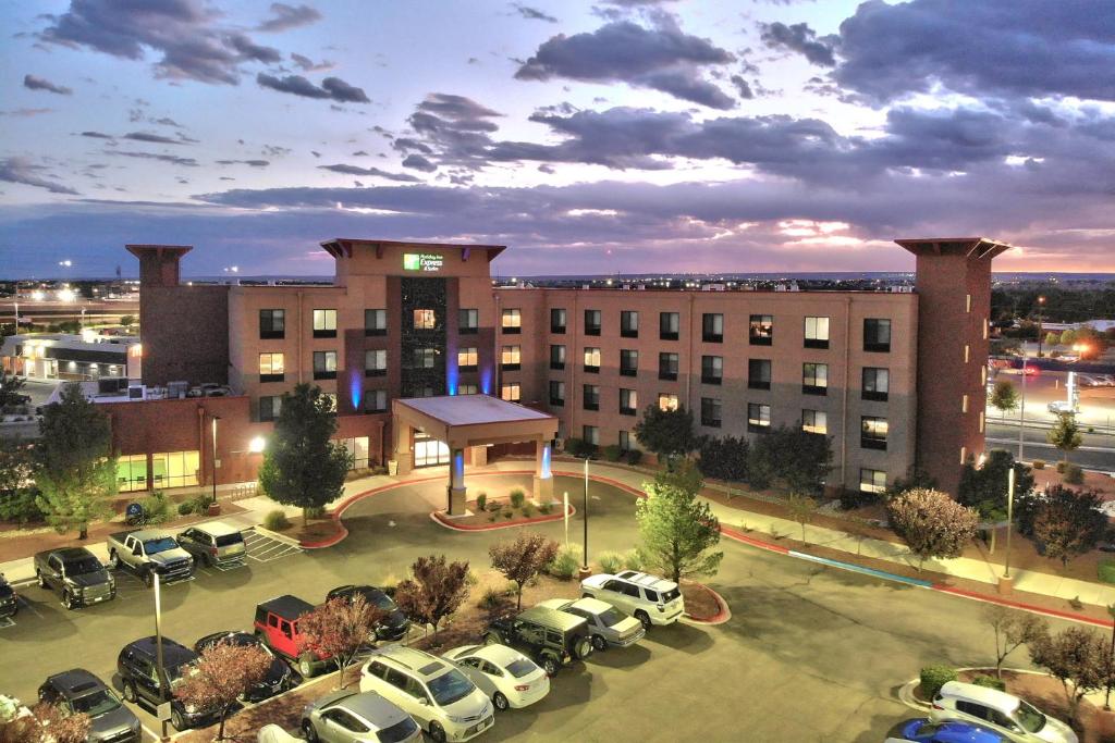 阿尔伯克基Holiday Inn Express & Suites Albuquerque Historic Old Town, an IHG Hotel的停车场内停放汽车的大型建筑