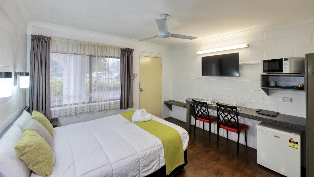 库纳巴拉布兰Azalea Motel的酒店客房配有一张床、一张书桌和一间厨房。