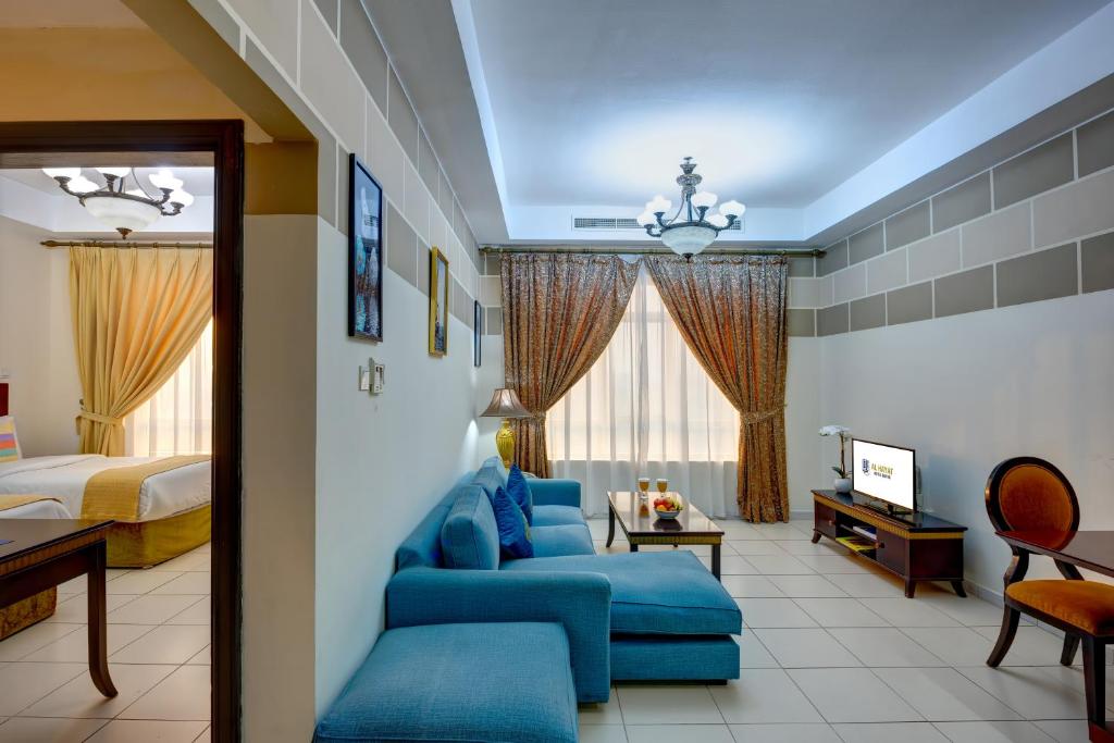 沙迦奥哈亚特公寓酒店的酒店客房配有蓝色的沙发和床。