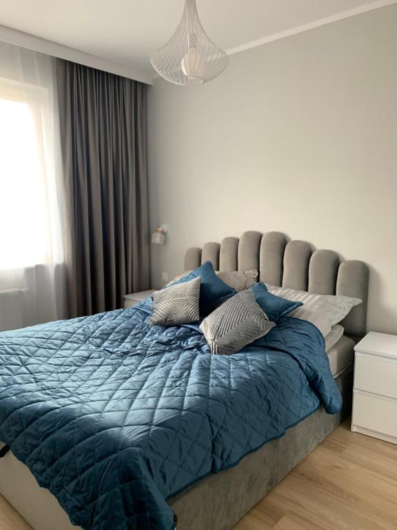 斯塔加德什切青Platinum De Lux Apartament的一间卧室配有一张带蓝色棉被的大床