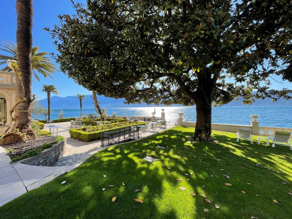 加尔尼亚诺茱莉亚别墅酒店的公园里有树和长凳,还有海洋
