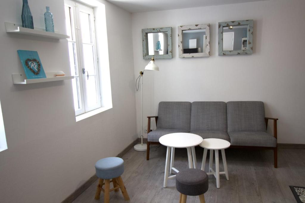 拉弗洛特Cosy Apartment In The Center Of La Flotte的客厅配有沙发、2张桌子和2面镜子
