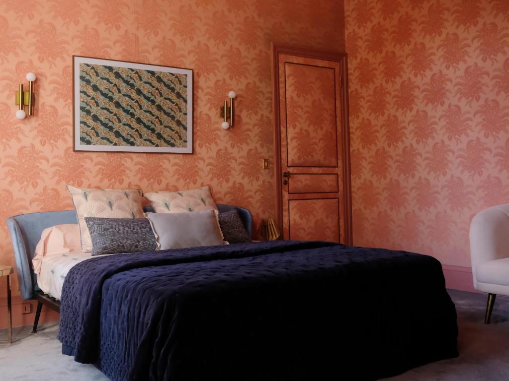 Saint-Martin-lez-TatinghemMille et une feuilles的卧室配有一张床,墙上挂着一幅画