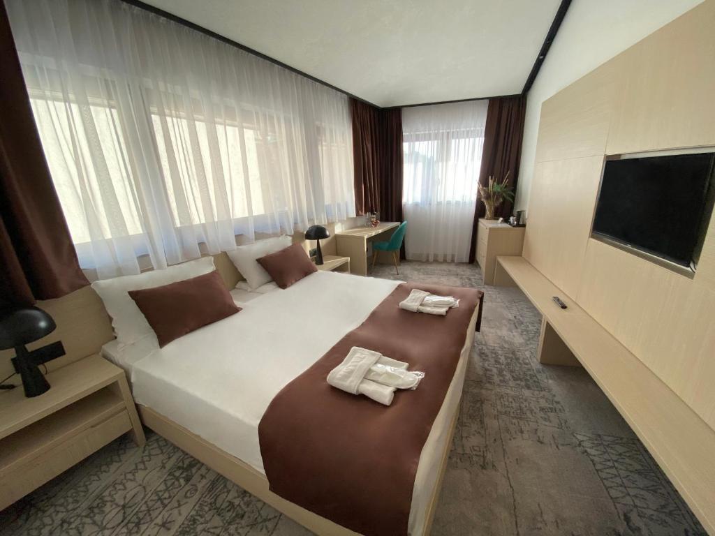 萨拉热窝Hotel Boss的一间卧室配有一张大床和两条毛巾