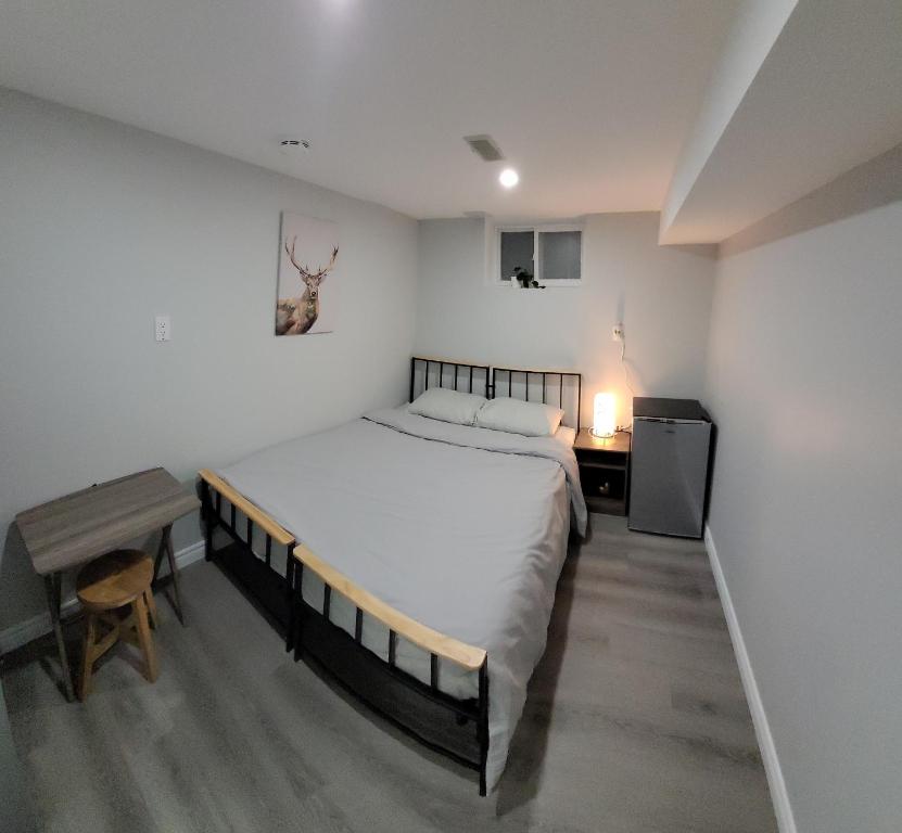 多伦多Guest House Basement - Master Bedrooms in Bayview Village的一间卧室配有一张大床、一张桌子和一张书桌
