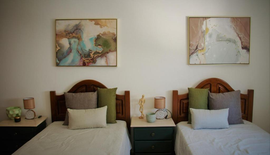 莫托拉Casa das Laranjeiras的两张床位于带两盏挂在墙上的灯的房间