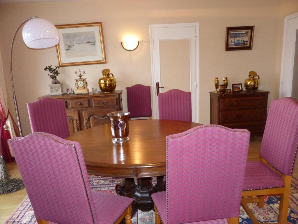 格朗维尔Résidence Saint-Nicolas Granville的一间带木桌和紫色椅子的用餐室