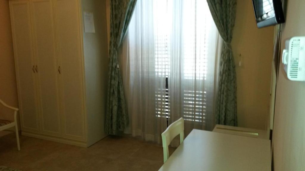 布林迪西曼佐尼住宿加早餐旅馆的客房设有桌子和带窗帘的窗户。