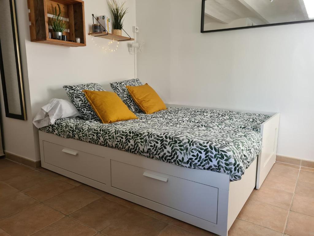 卡尔特汉Studio vallon d'Azur à Carqueiranne的一张床上的黄色枕头