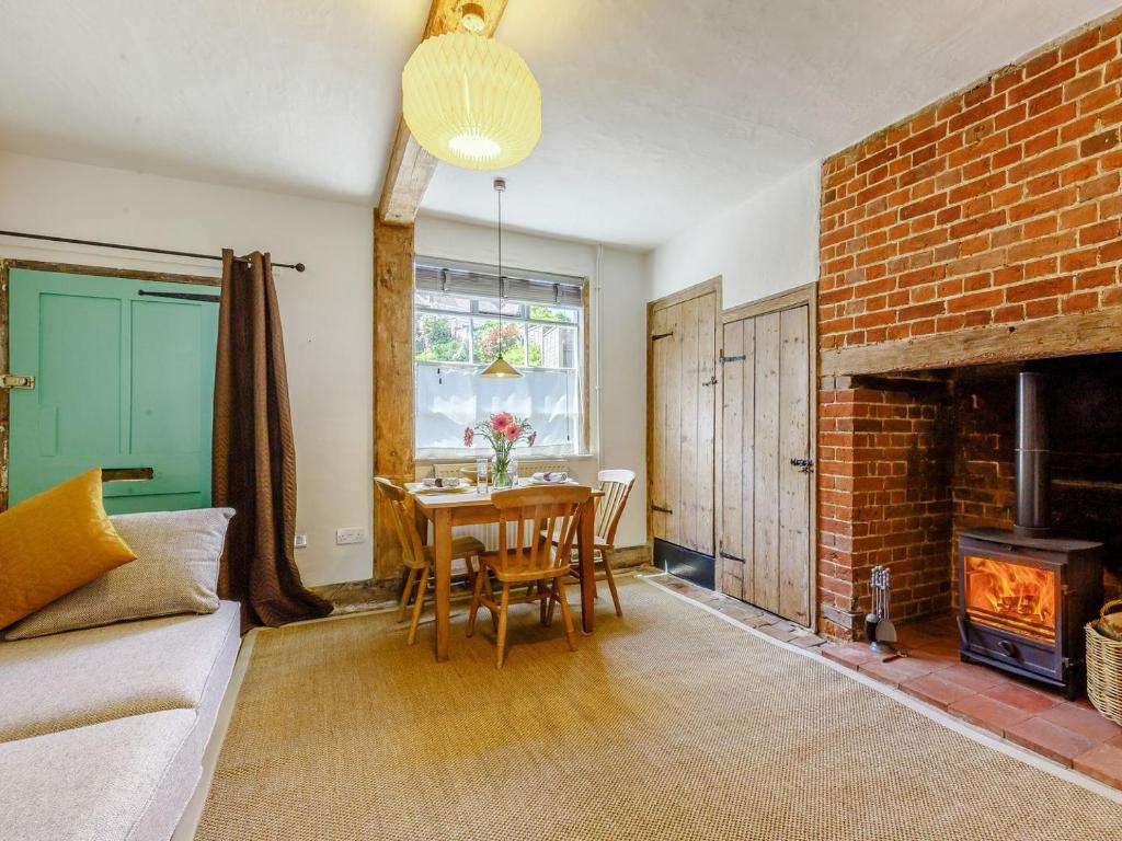 伍德布里奇Angel Lane的客厅配有桌子和砖砌壁炉