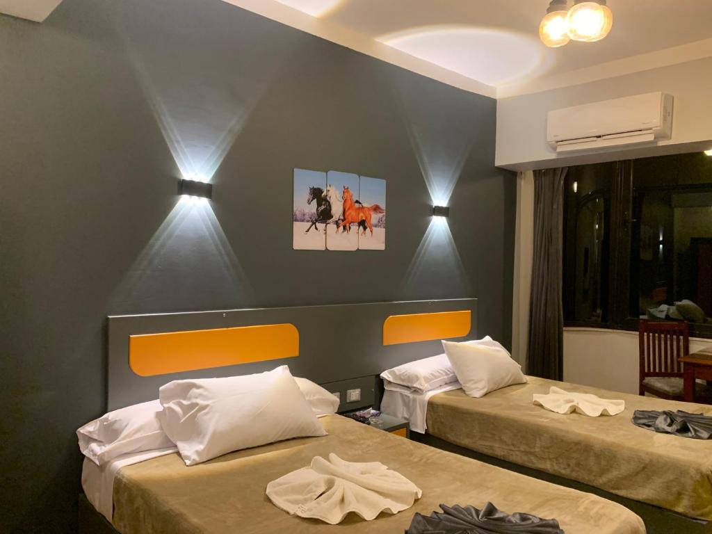 QināRoyal Hotel的一间客房内配有两张床的房间