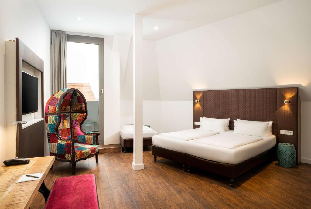 莱比锡elaya hotel leipzig city center的一间酒店客房,配有一张床和一台电视