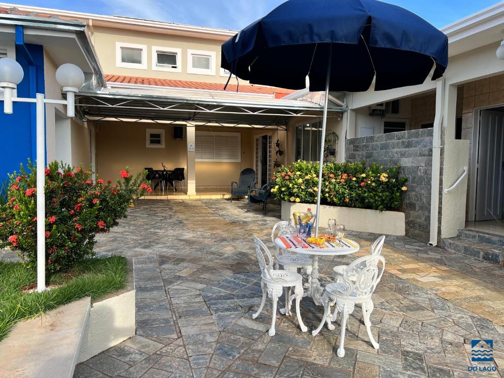 普雷图河畔圣若泽Hostel do Lago的庭院配有桌椅和遮阳伞。
