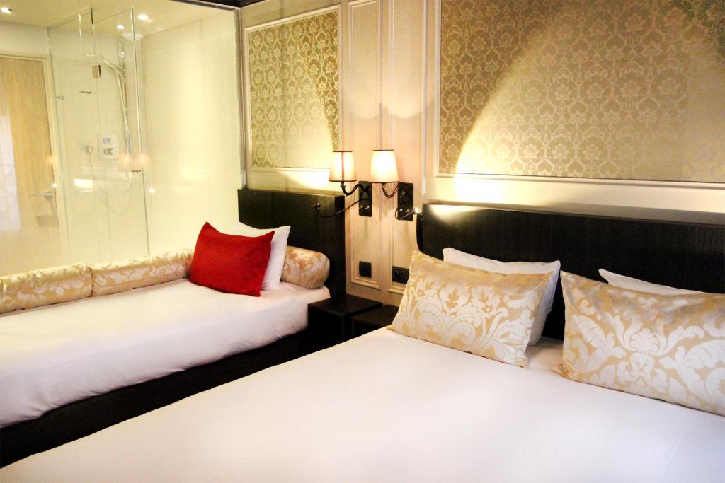 巴黎乐蒙马特圣皮埃尔贝斯特韦斯特酒店的酒店客房 - 带两张带红色枕头的床