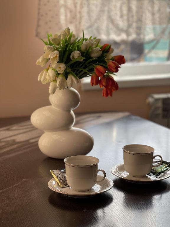 奇姆肯特Mondial apartments的一张桌子,上面有两杯,花瓶