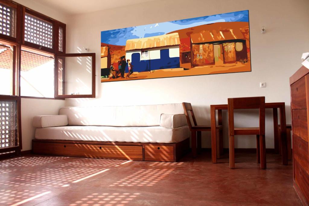 明德卢Paz Apartment的客厅配有沙发和墙上的绘画