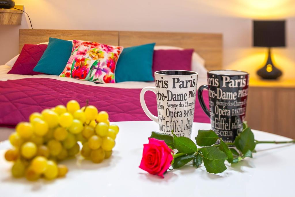 比亚韦斯托克马戈别墅旅舍的两个咖啡杯坐在桌子上,花朵