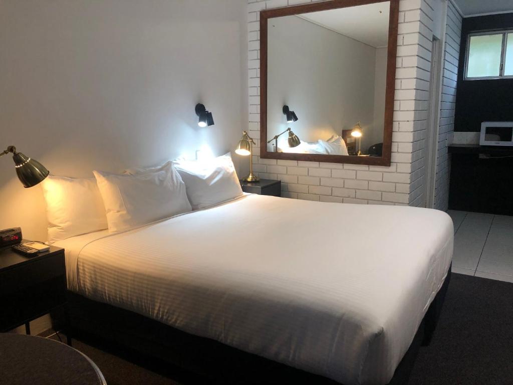科夫斯港斗牛士汽车酒店的卧室配有一张白色大床和镜子