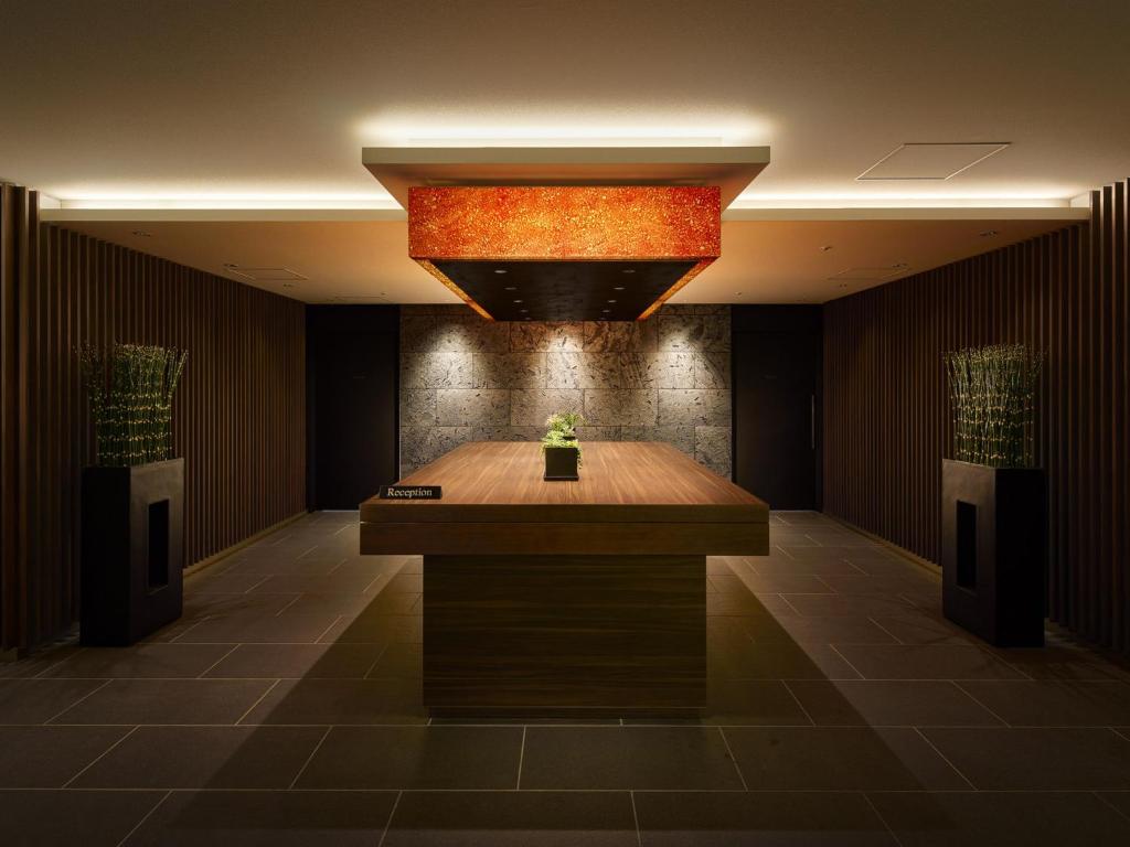 大阪Villa Fontaine Grand Osaka Umeda的大厅,房间中间设有一张桌子