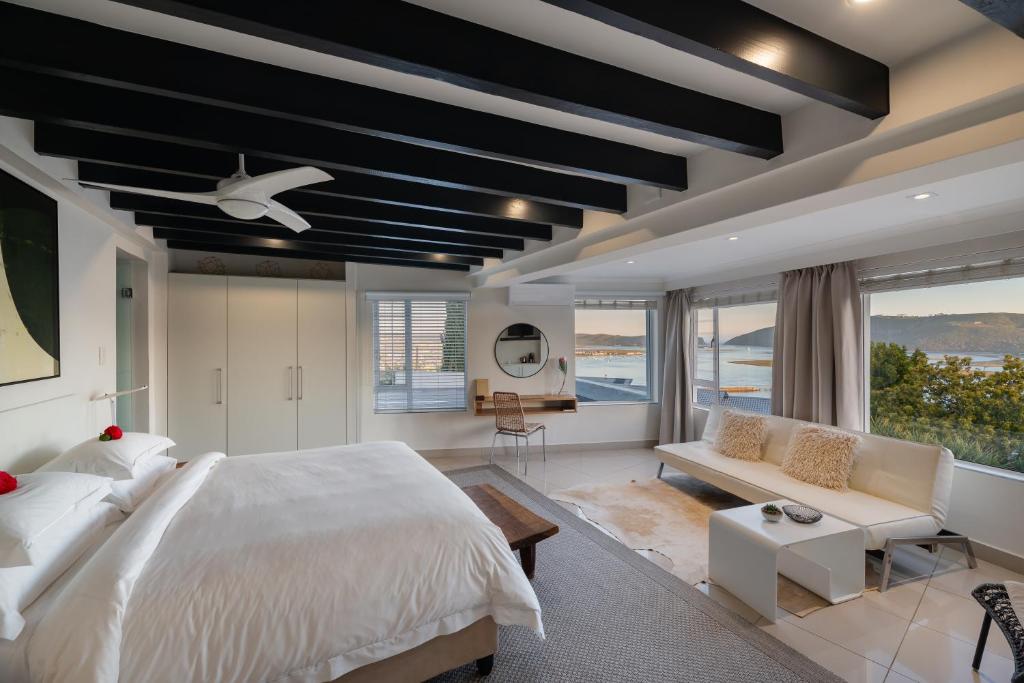 克尼斯纳Villa Afrikana Guest Suites by Knysna Paradise Collection的卧室配有一张白色的大床和一张沙发。