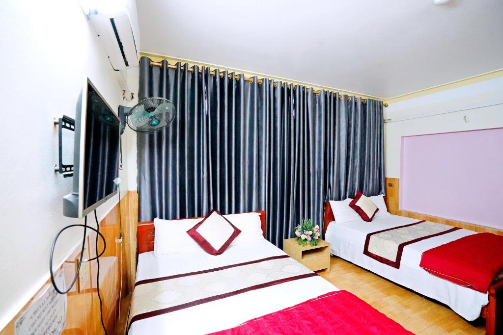 宁平New Nhat Minh HomeStay的酒店客房设有两张床和窗户。