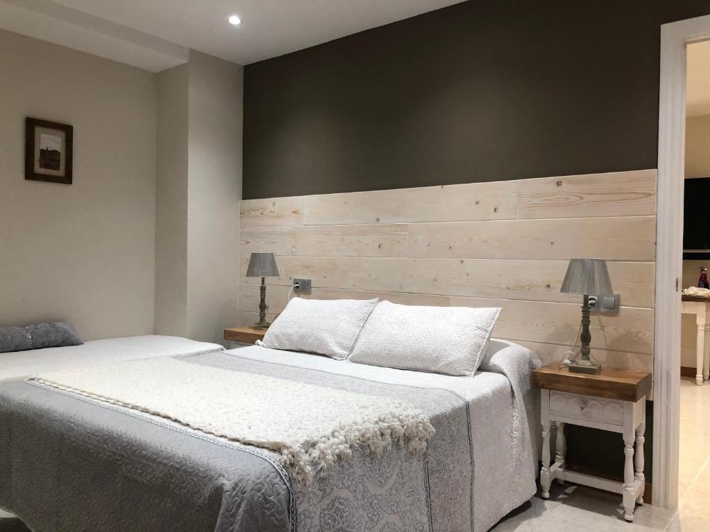 维拉诺瓦Hotel Apartamentos Barrau的一间卧室设有一张床和木墙