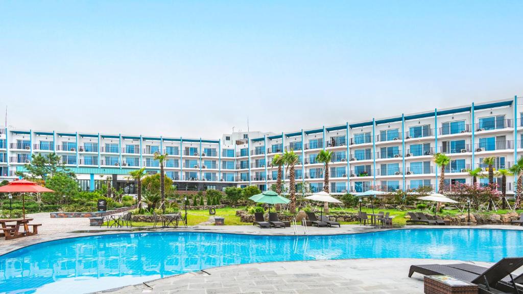 济州市Hallim Resort的一座带游泳池和大型建筑的酒店