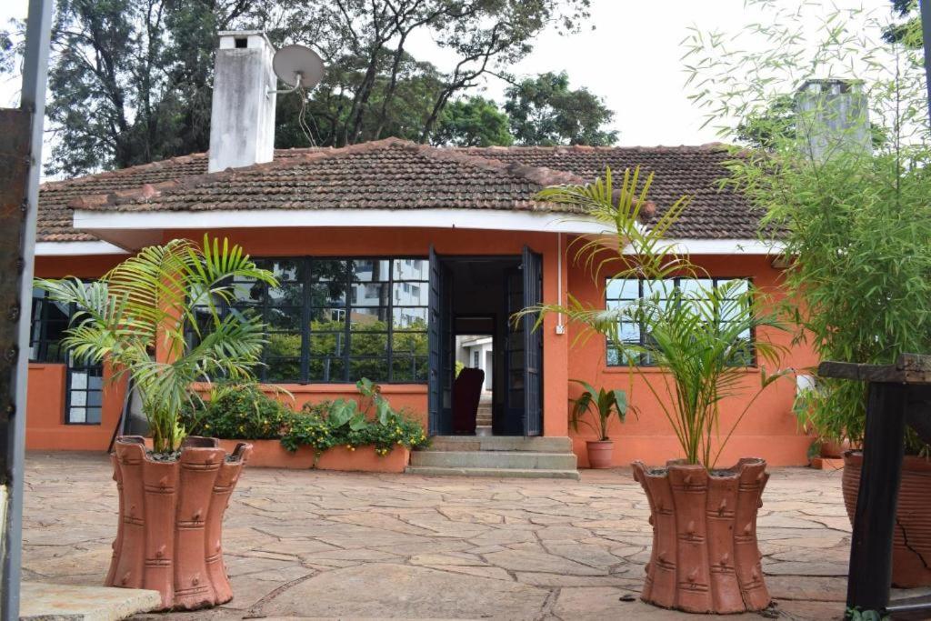 内罗毕Sochati Casa Resort的一座种植了植物的橙色小房子