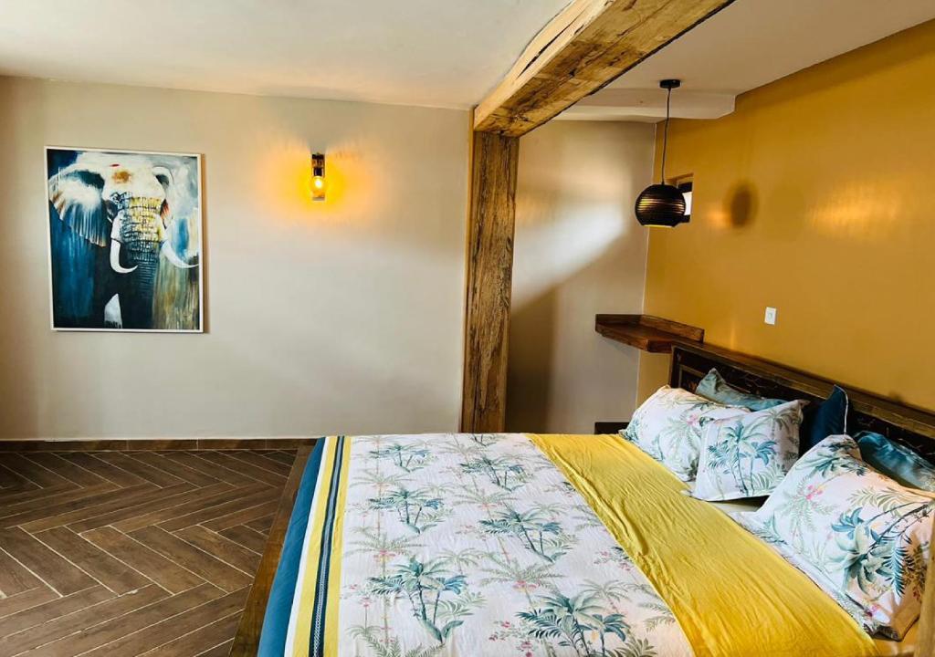 MakindyeThe Forest Resort - Lweza的一间卧室配有一张床,一张大象的照片