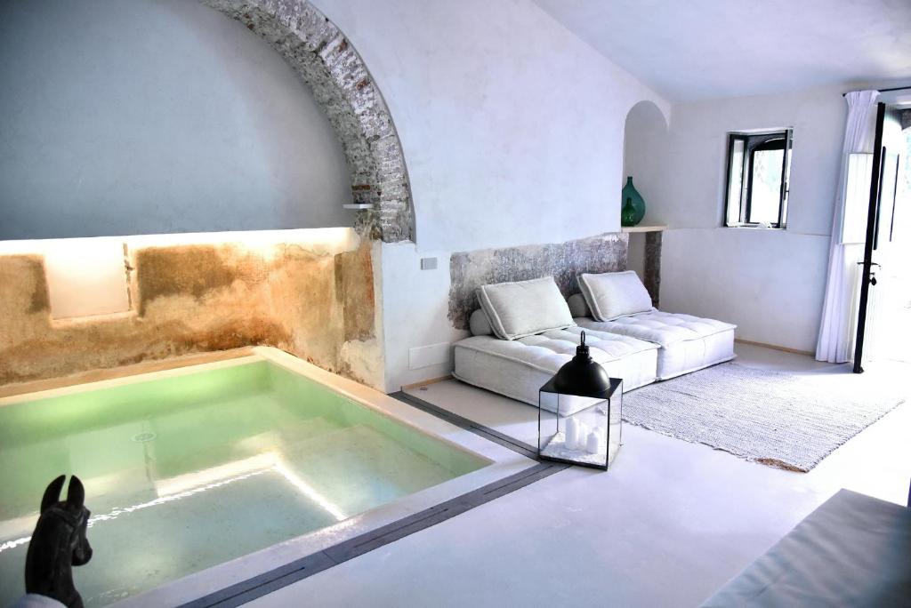 卡拉塔比亚诺圣马可城堡魅力Spa酒店的客厅设有浴缸,配有沙发