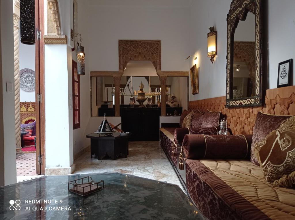 塞拉Riad Dar Badiaa的带沙发和玻璃桌的客厅