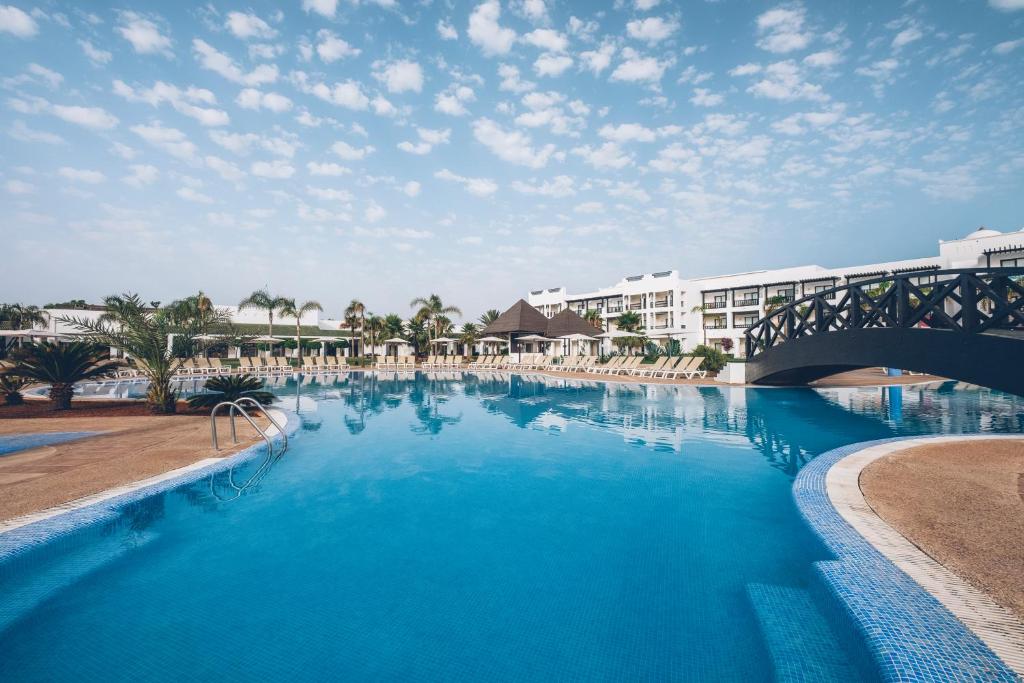 萨伊迪耶伊波罗之星度假酒店的一座带桥梁的度假村内的大型游泳池