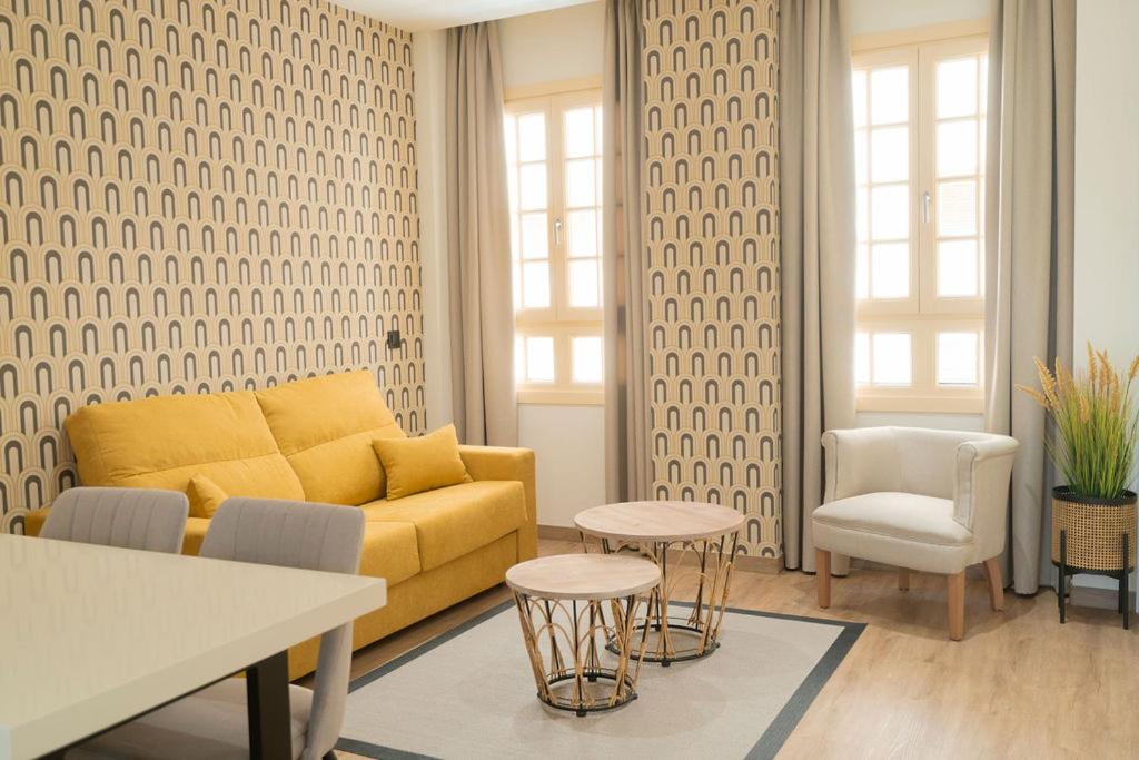 马拉加Suites Chinitas的客厅配有黄色的沙发和椅子