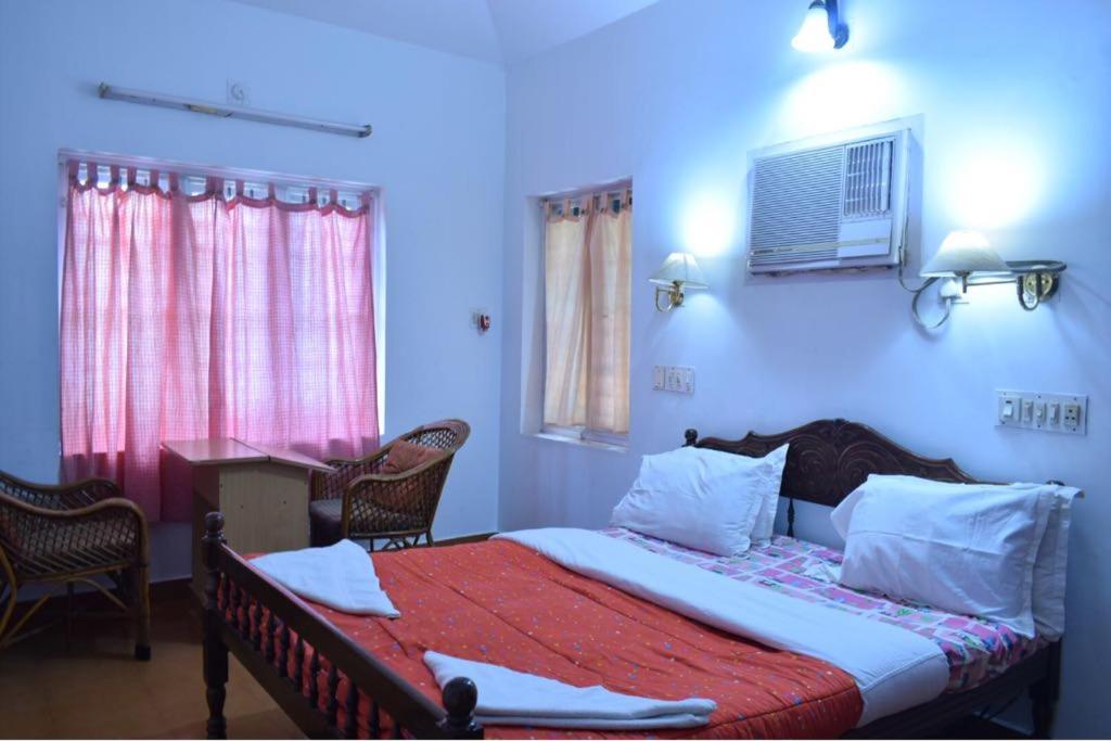 科钦Sithara Homestay Fort Cochin的卧室配有一张床和一张桌子及椅子