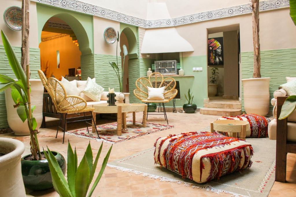 马拉喀什里亚德阿姆拉酒店的客厅配有床和桌椅