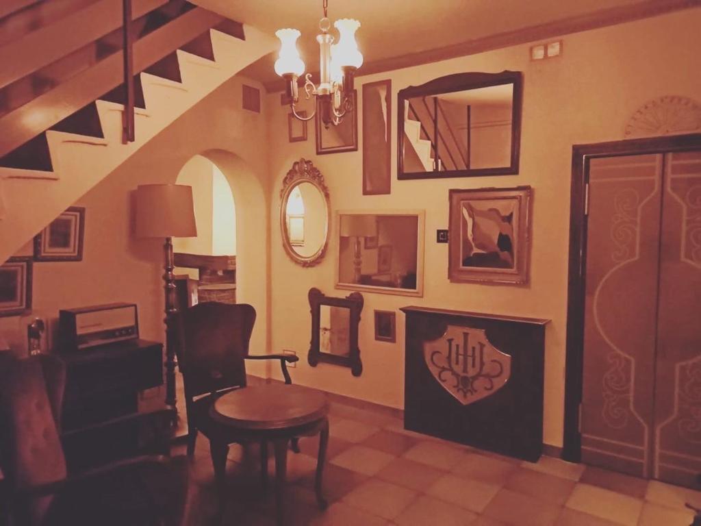 贝尔加Insomnia Hotel的客厅设有楼梯、桌子和椅子