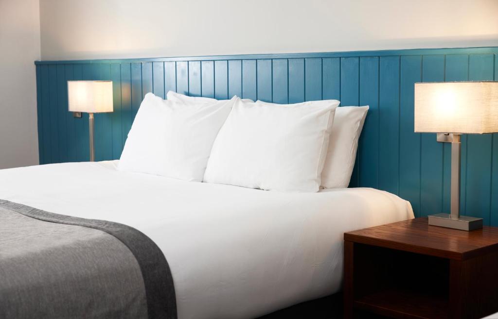 米德尔斯伯勒Highfield Hotel的一间卧室配有一张带白色枕头的床和两盏灯。