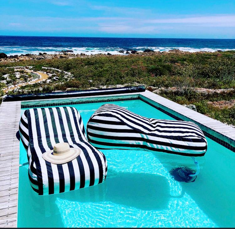 贝蒂湾Kalliste an exclusive retreat的一个带2把躺椅的游泳池和海滩