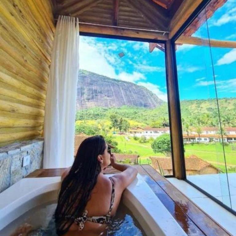 Simão PereiraHotel Fazenda Santa Helena的浴缸中的女人,享有山景