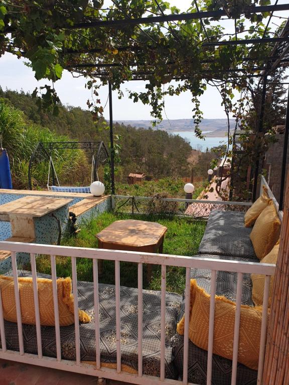 Oulad YakoubFerme Bouhouch的客房设有带桌子和长凳的阳台。