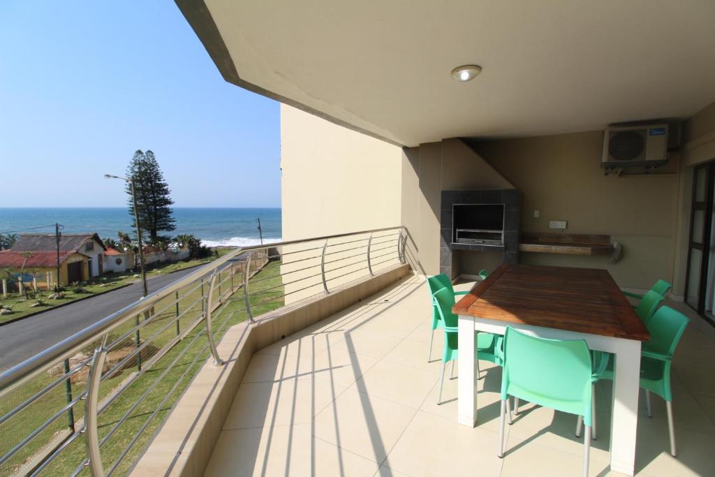 乌旺戈海滩Saints View Resort Unit 9的一个带桌椅的海景阳台