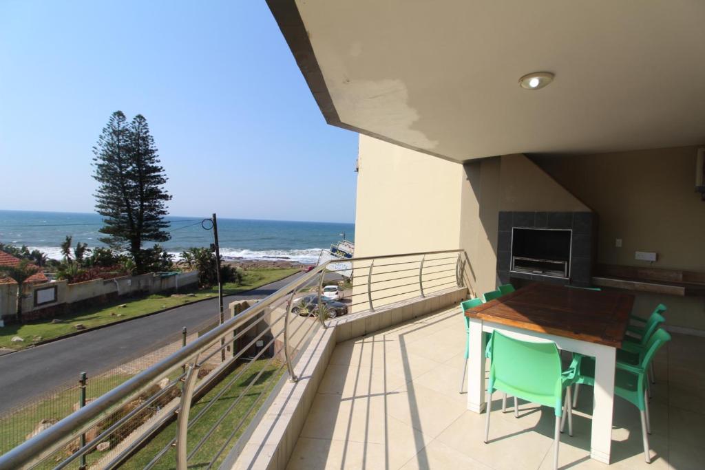 乌旺戈海滩Saints View Resort Unit 12的阳台配有桌椅,享有海景。