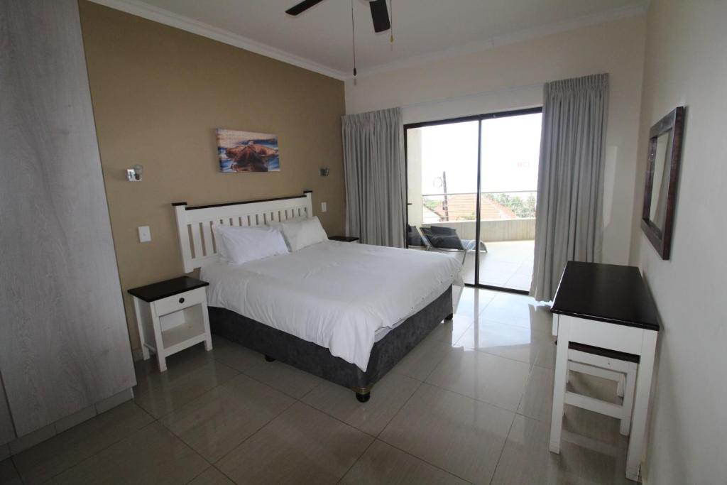 乌旺戈海滩Saints View Resort Unit 13的一间卧室配有一张床、一张书桌和一个窗户。