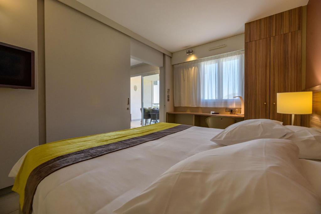 阿雅克修阿加西奥阿米劳特酒店的窗户客房内的一张大白色床
