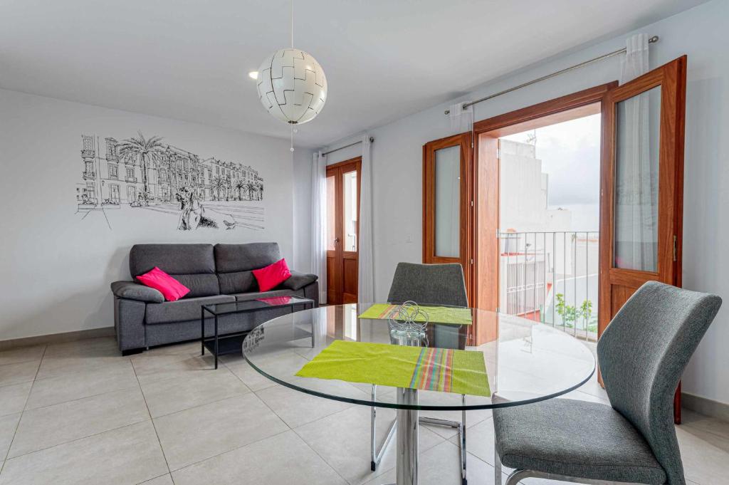 大加那利岛拉斯帕尔马斯Vegueta Luxury Apartments的客厅配有玻璃桌和椅子