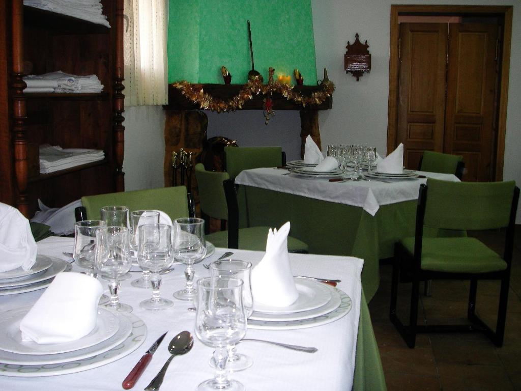 RibatajadillaHotel Rural El Cuco的用餐室配有带盘子和酒杯的桌子